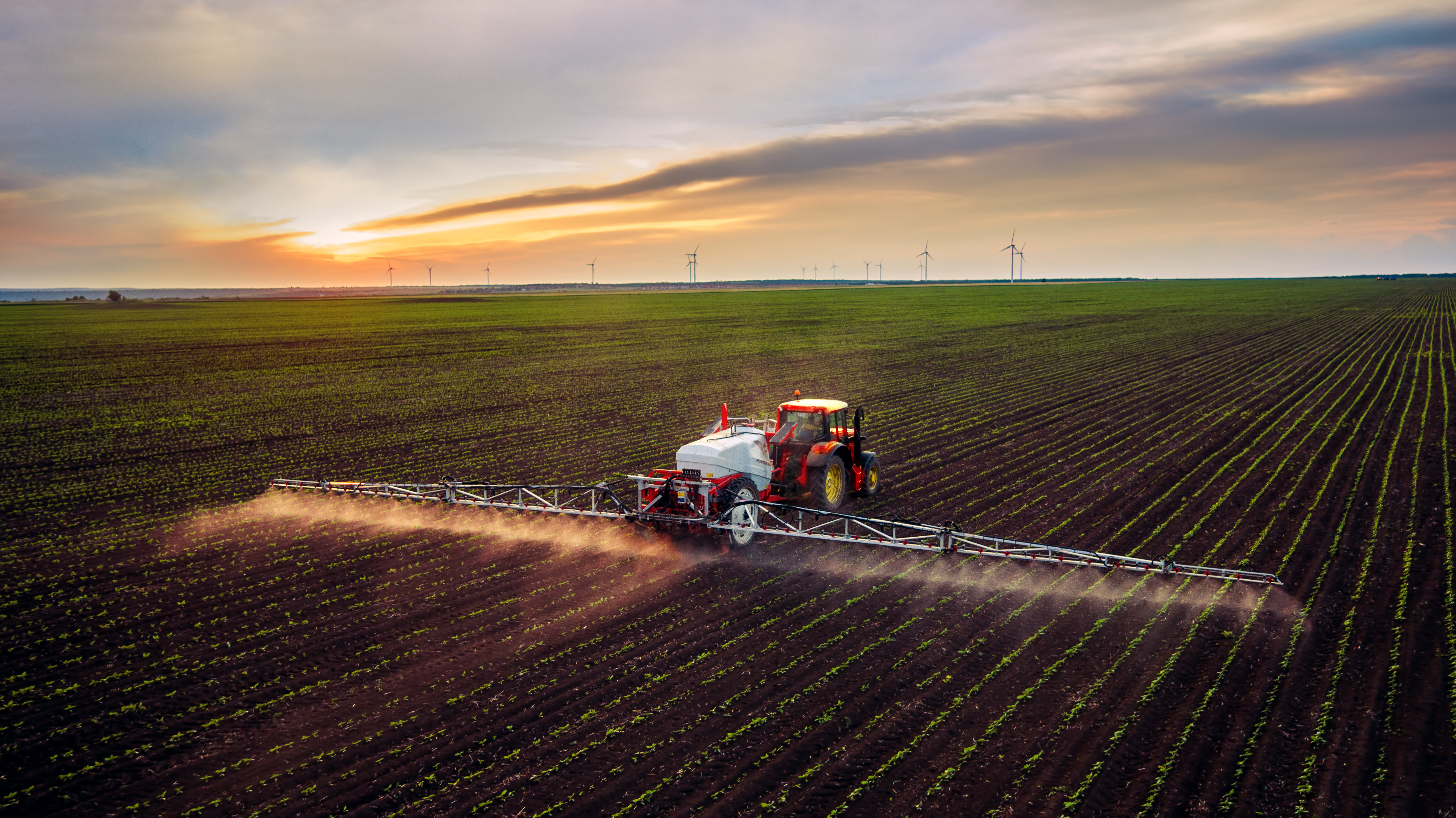 large multi-row sprayer adding chemicals to a field