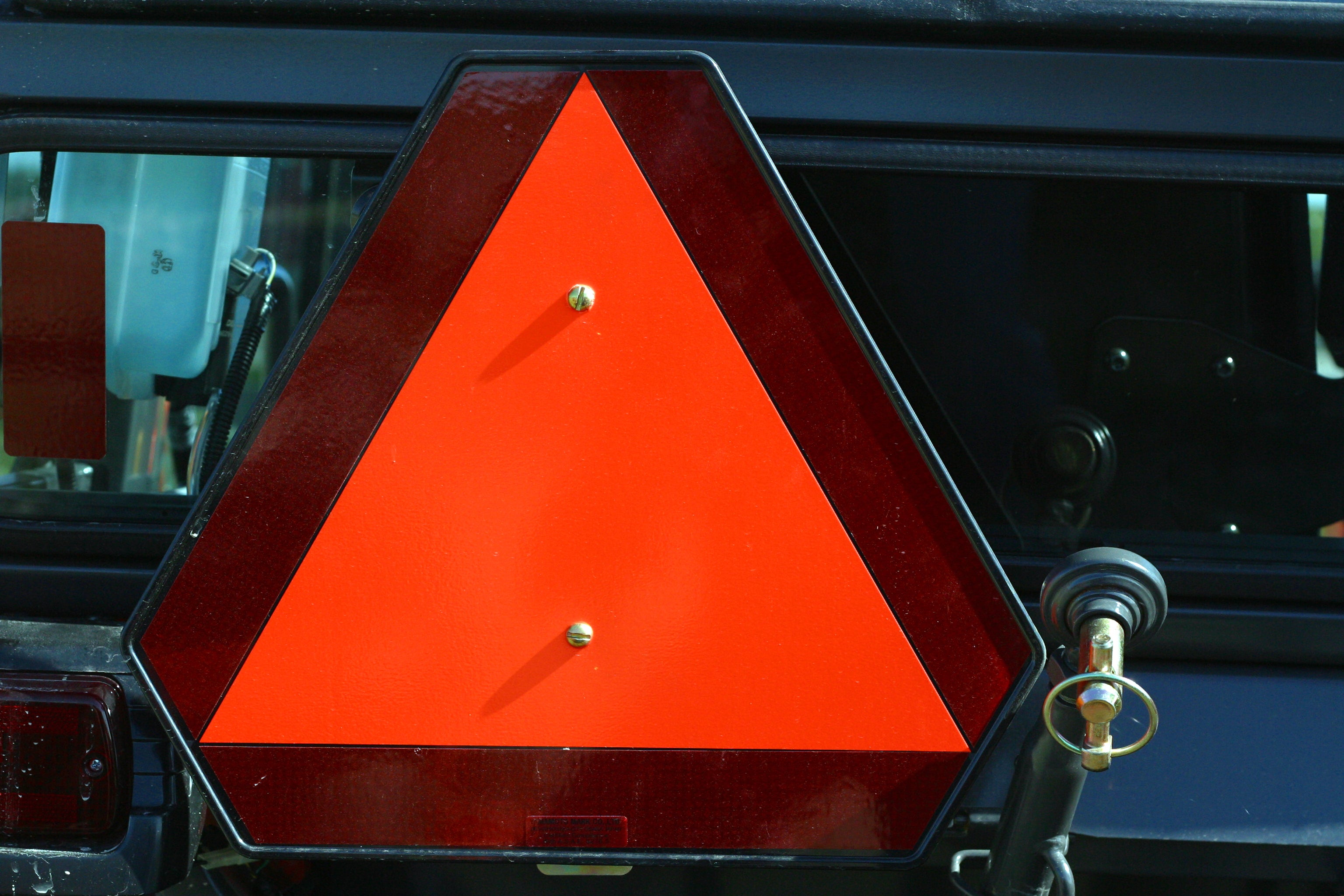 orange reflective safety triangle on a piece of farm equipment