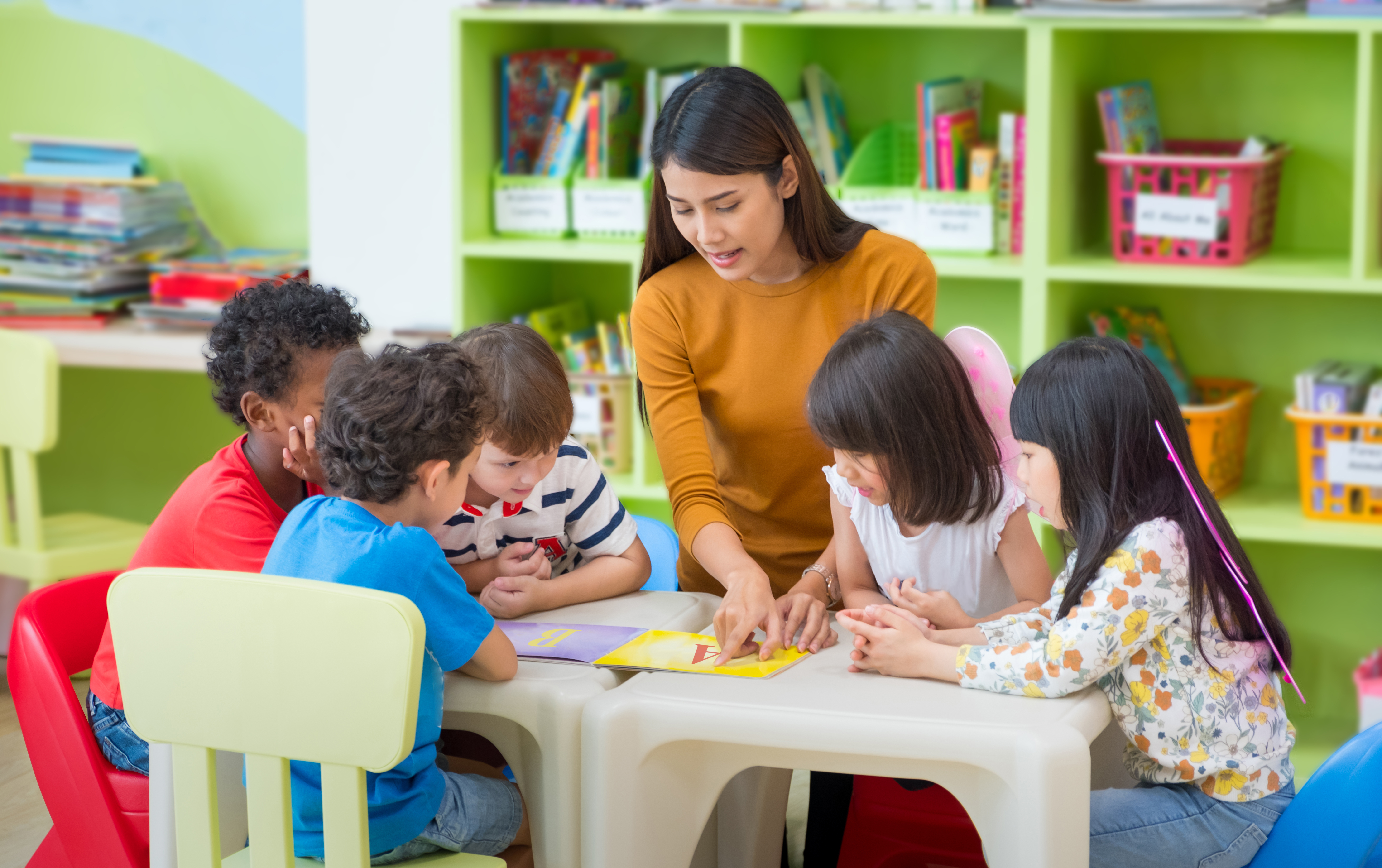 teacher with a small group of children learning at a table