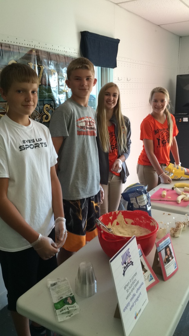 Youth working a fruit and yogurt snack table