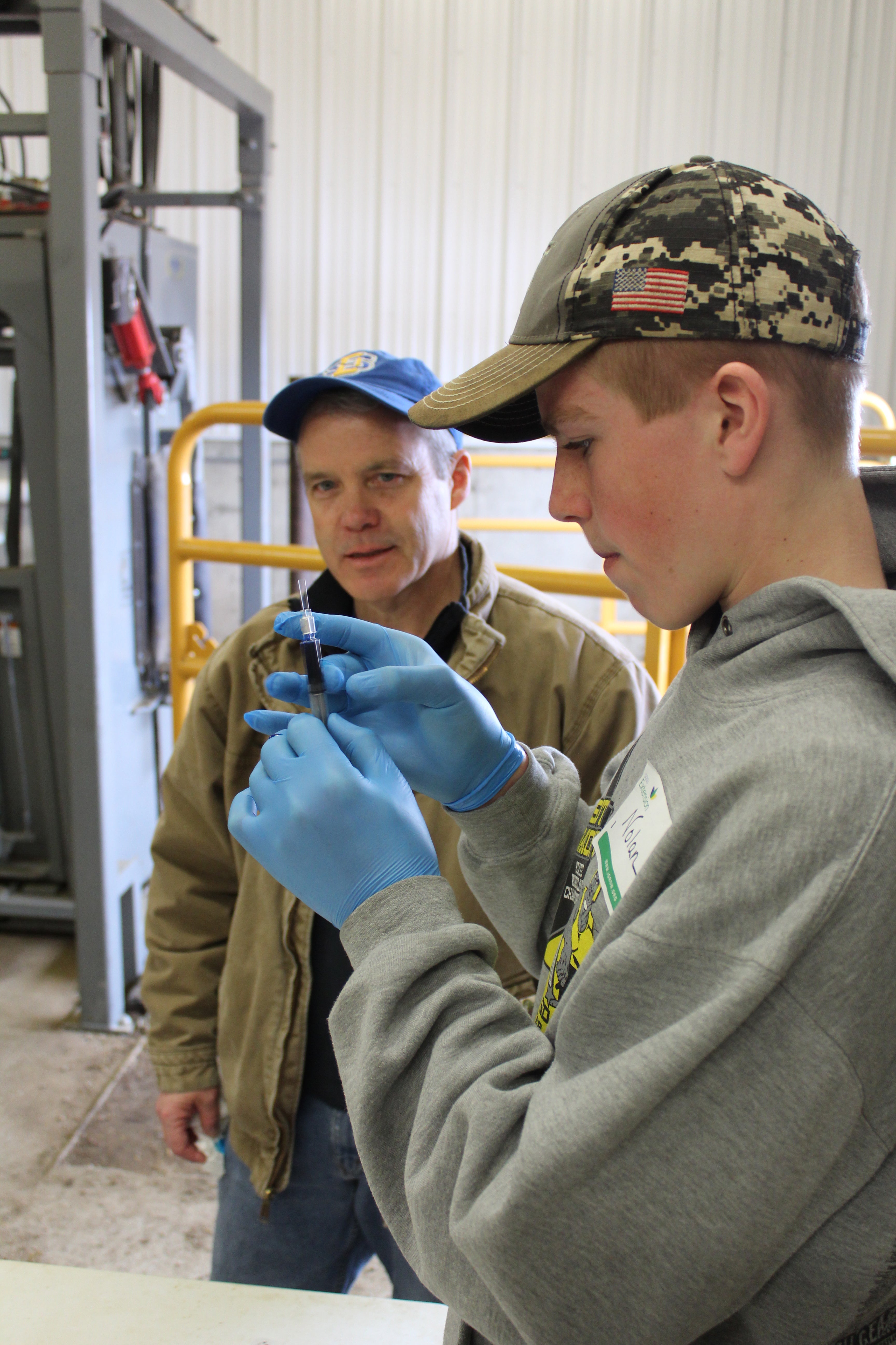 Nolan Dvorak learns how to correctly load a syringe under the supervision of Russ Daly