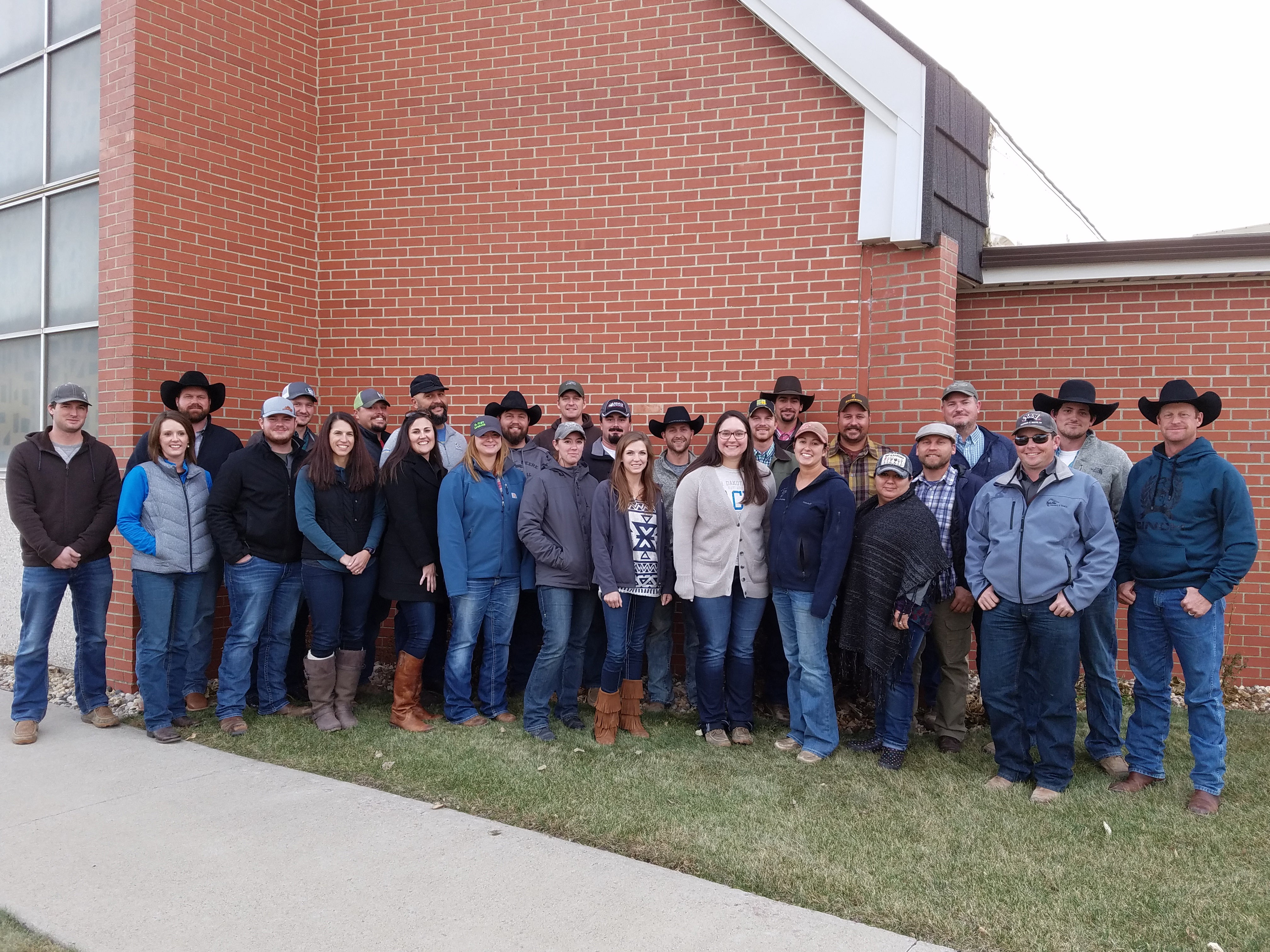image of a group of farmers and ranchers in front of a brick building