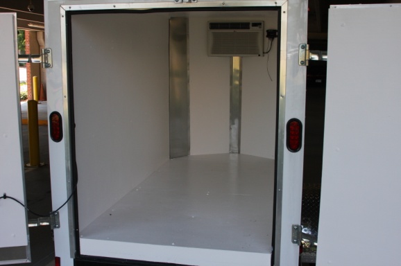 An empty inside of a medium-size trailer. A cooling unit can be seen at the back of the storage place.
