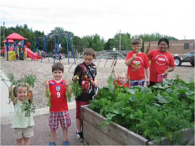 several children next to a raised garden