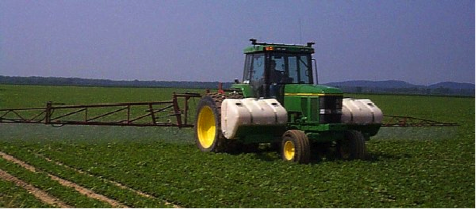 a tractor in a field spraying soybeans