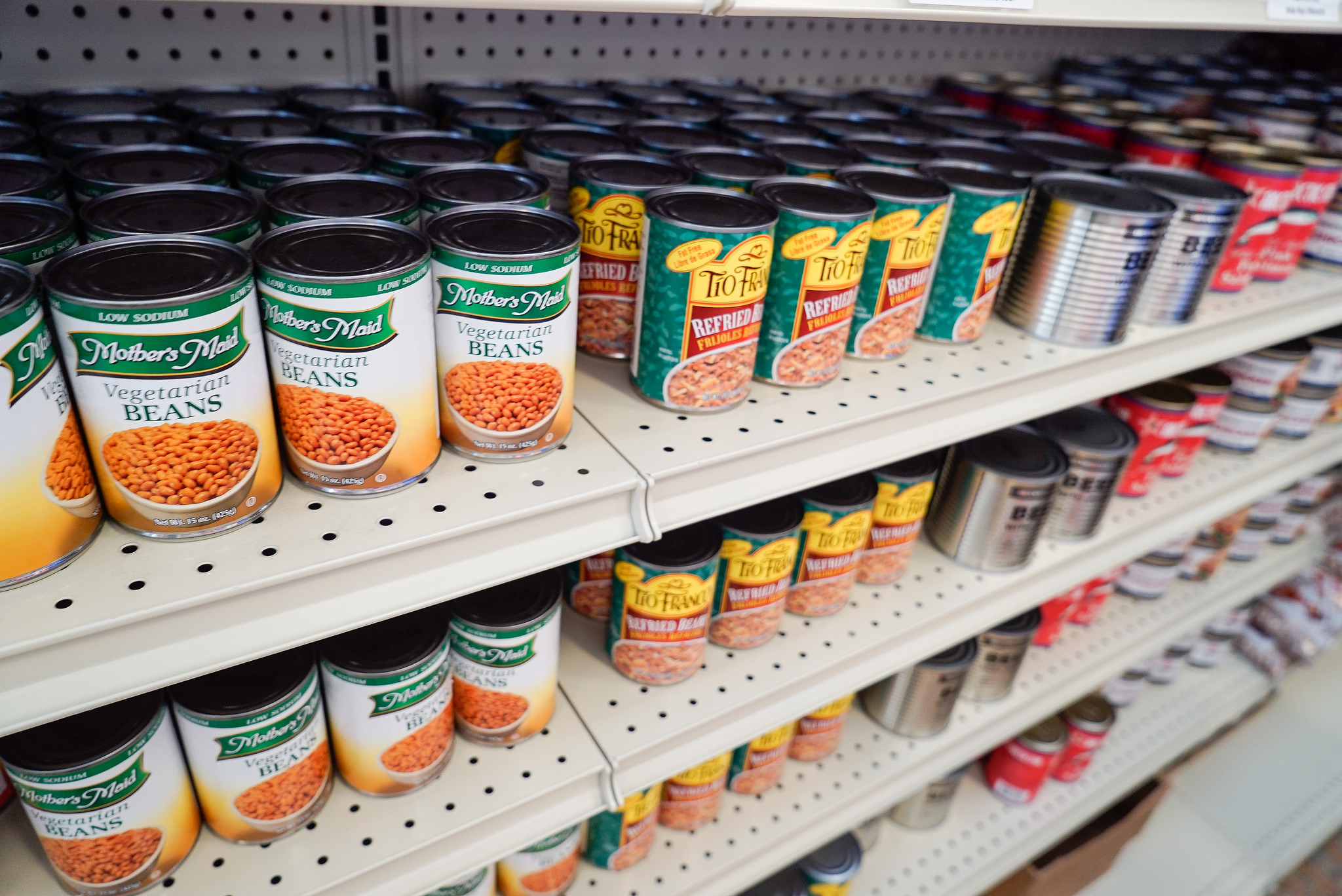 Canned vegetables on a grocery store shelf.