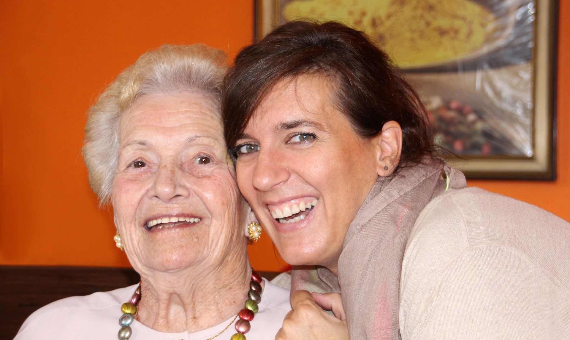 Older woman and her granddaughter smiling while they pose for a picture.
