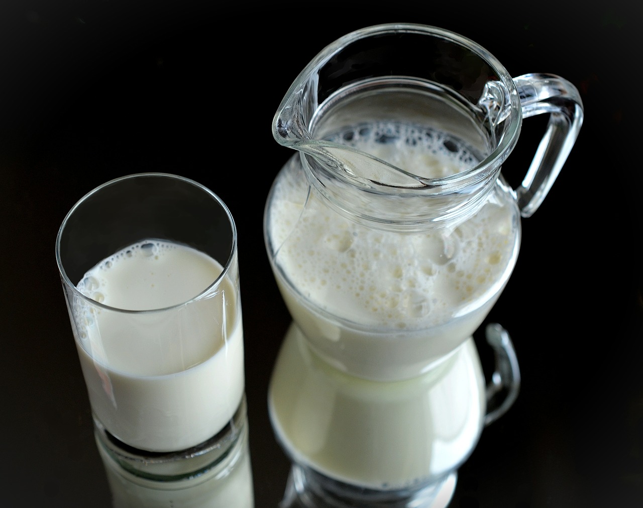 A glass of milk and a milk pitcher