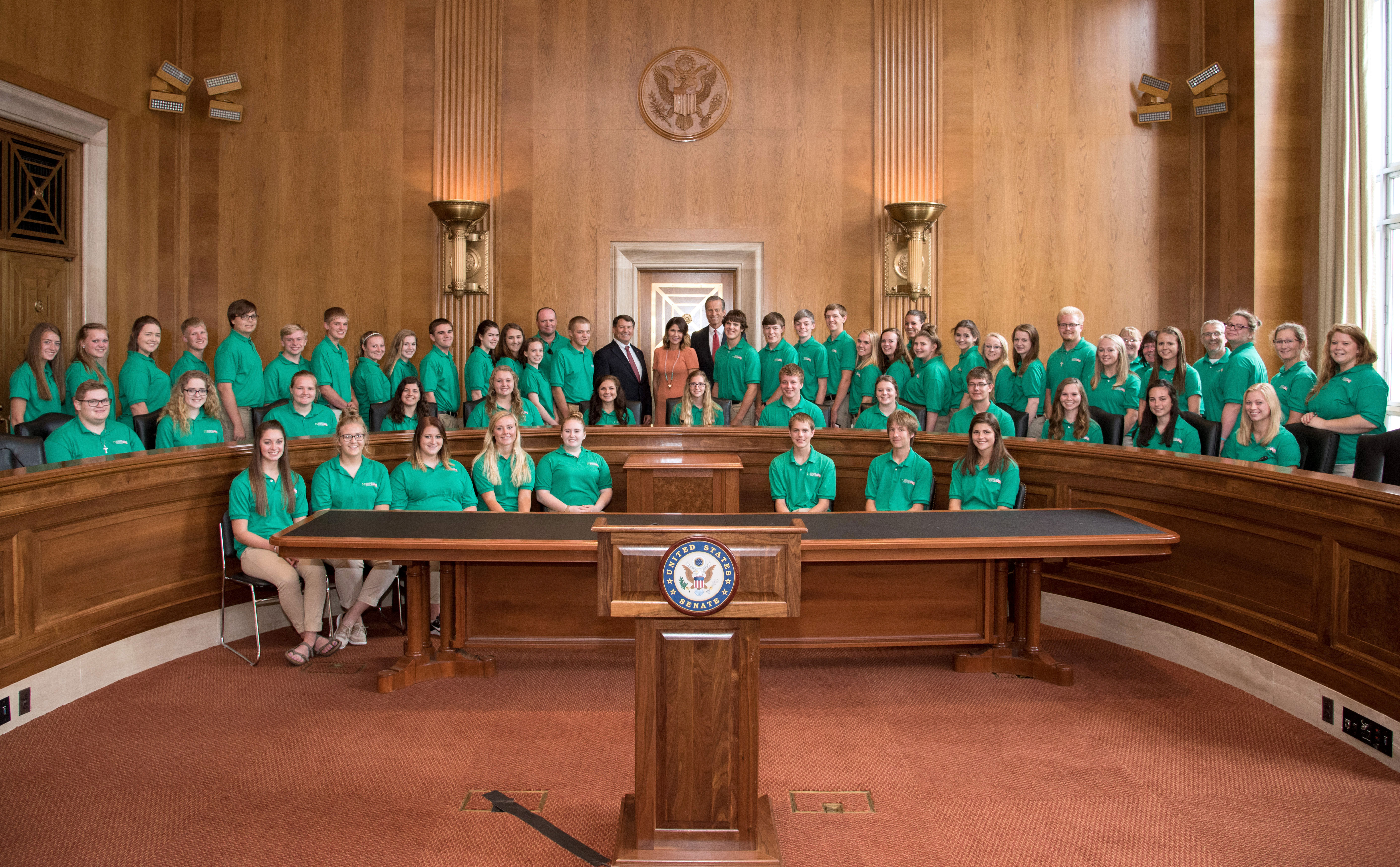 large group of 4-H youth posing for a photo with U.S. government officials inside a governmental chamber