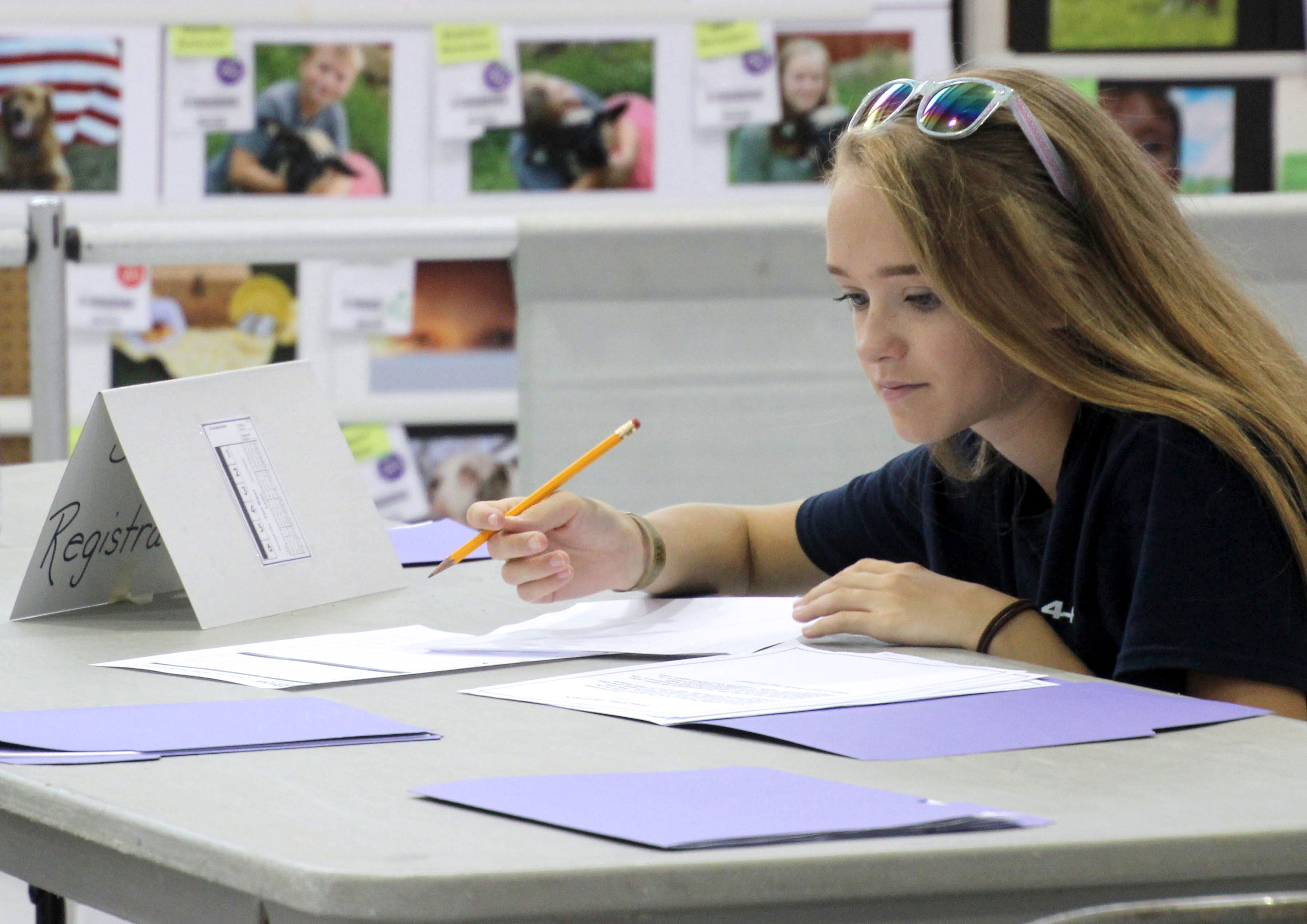 female 4-H youth reviewing paperwork at a table