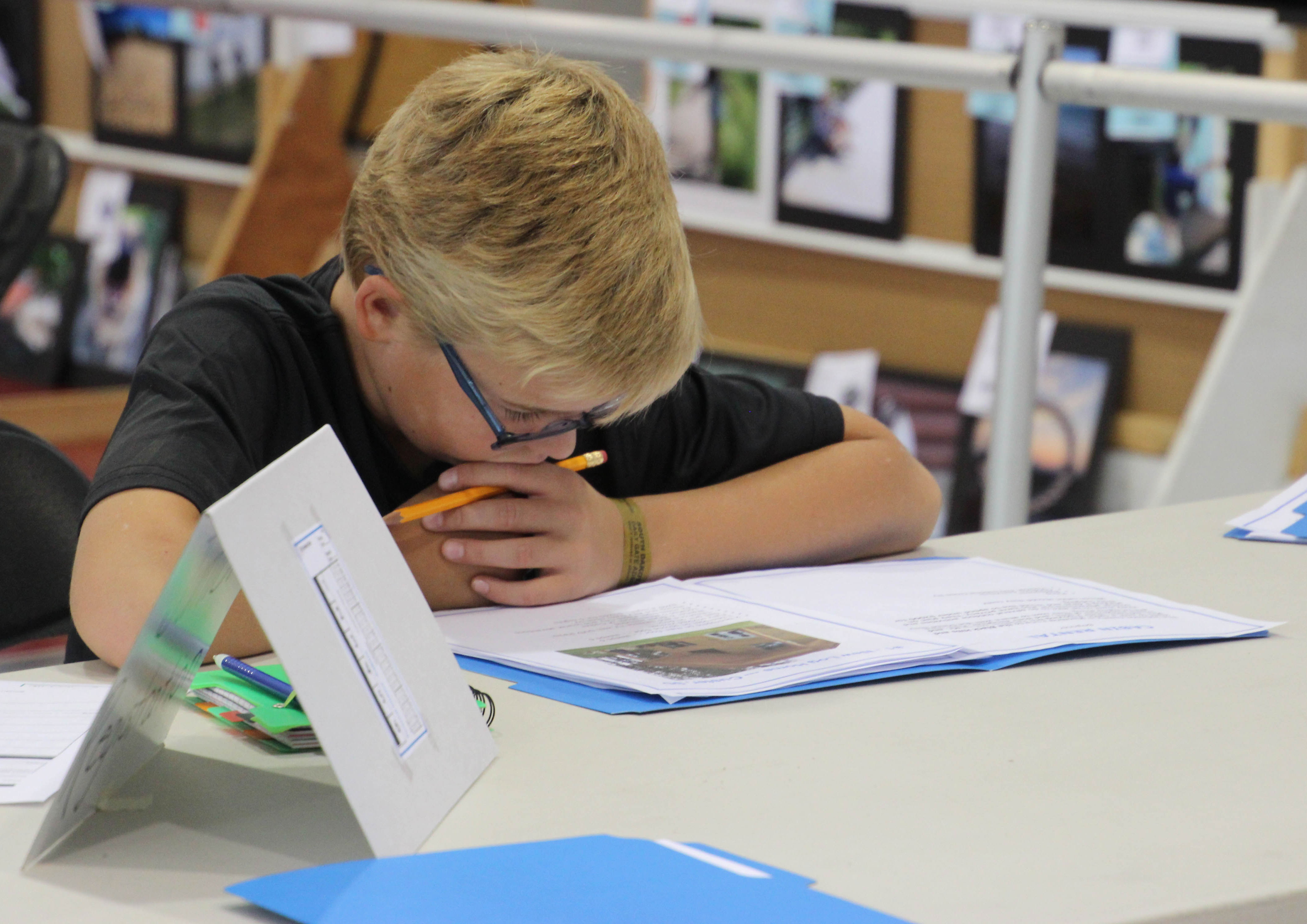 male 4-H youth reviewing paperwork at a table