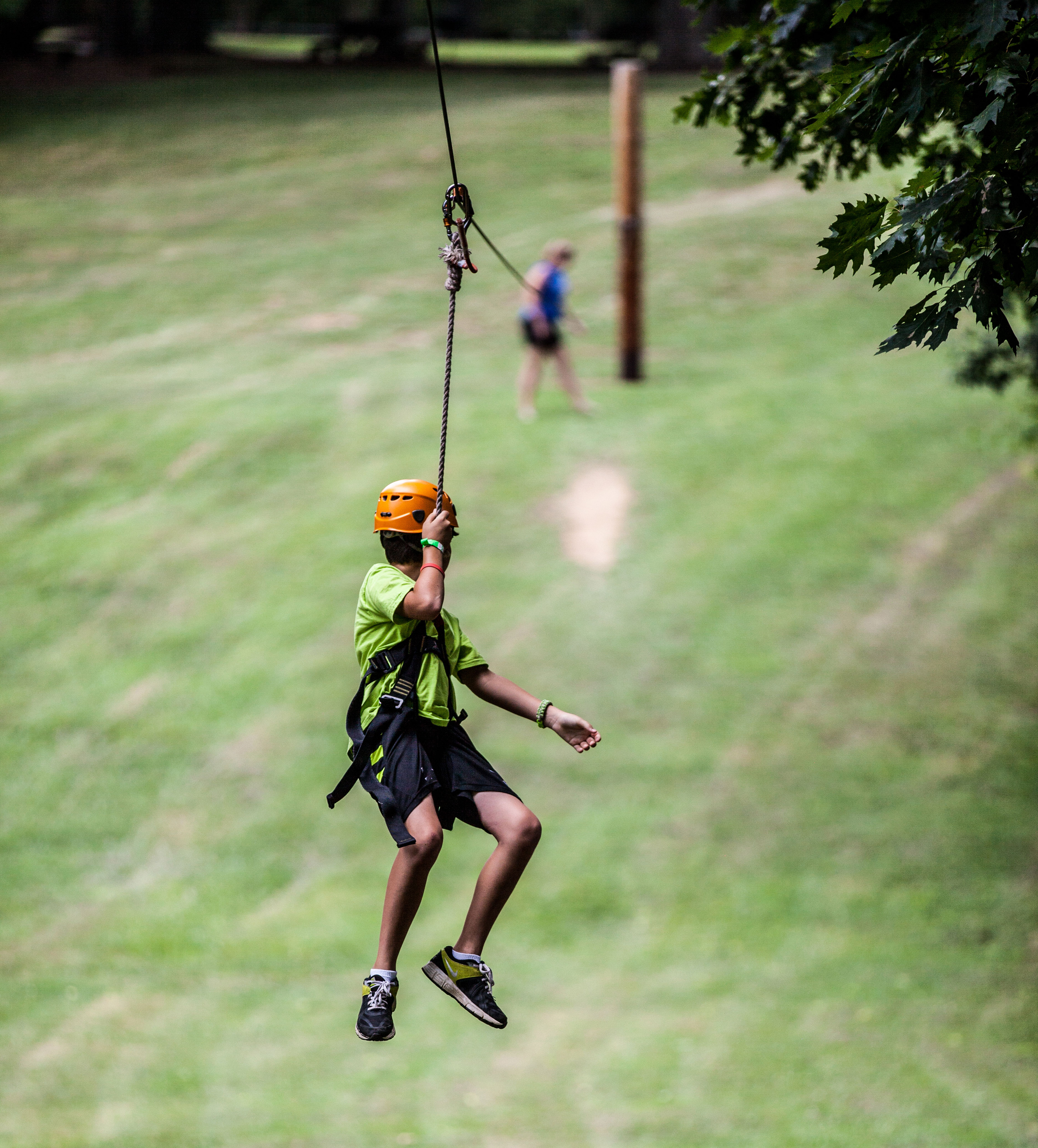 a young male swinging down a zip line