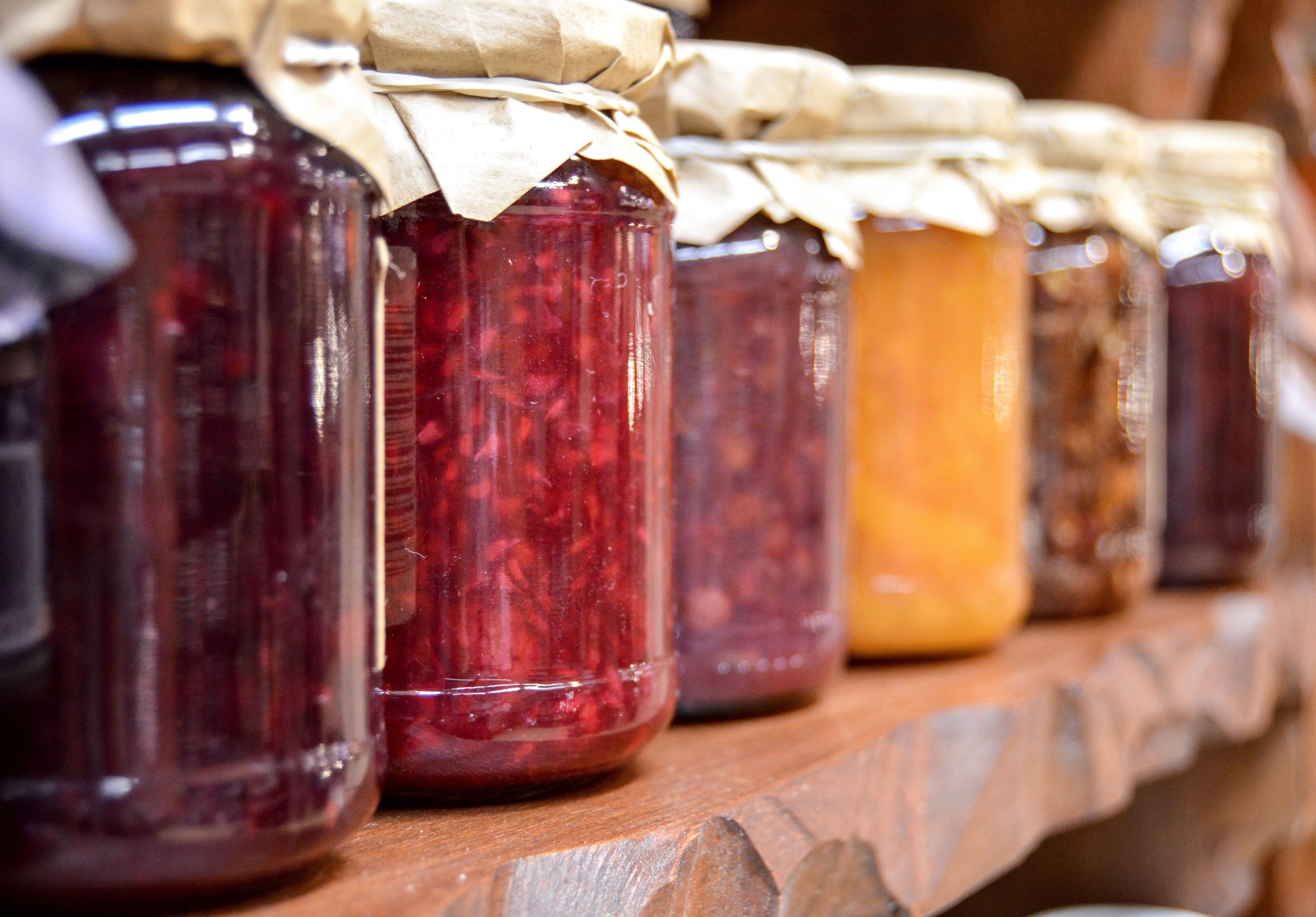 cans of various jams and jellies on a shelf