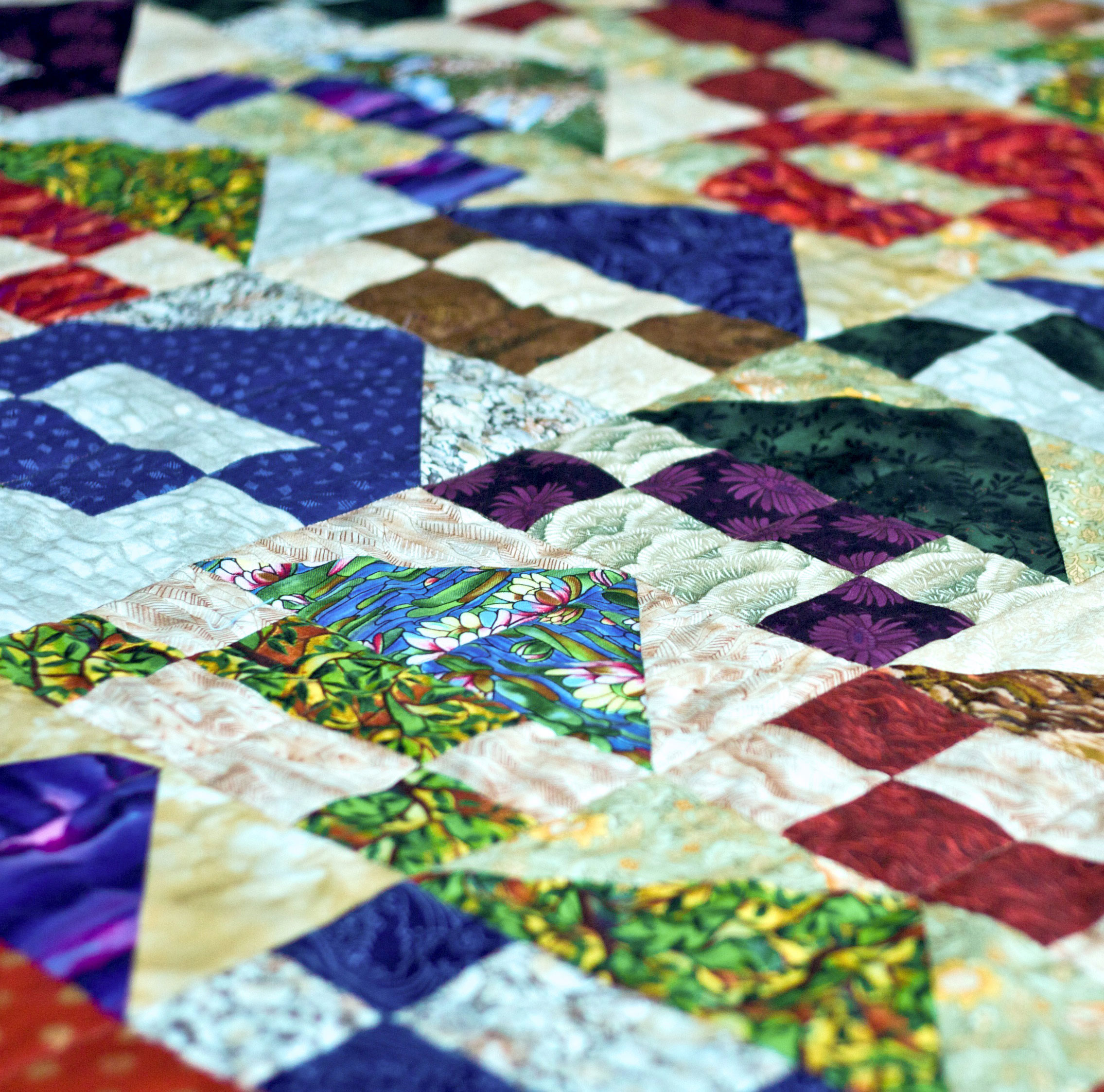 a homemade quilt with various pattern blocks