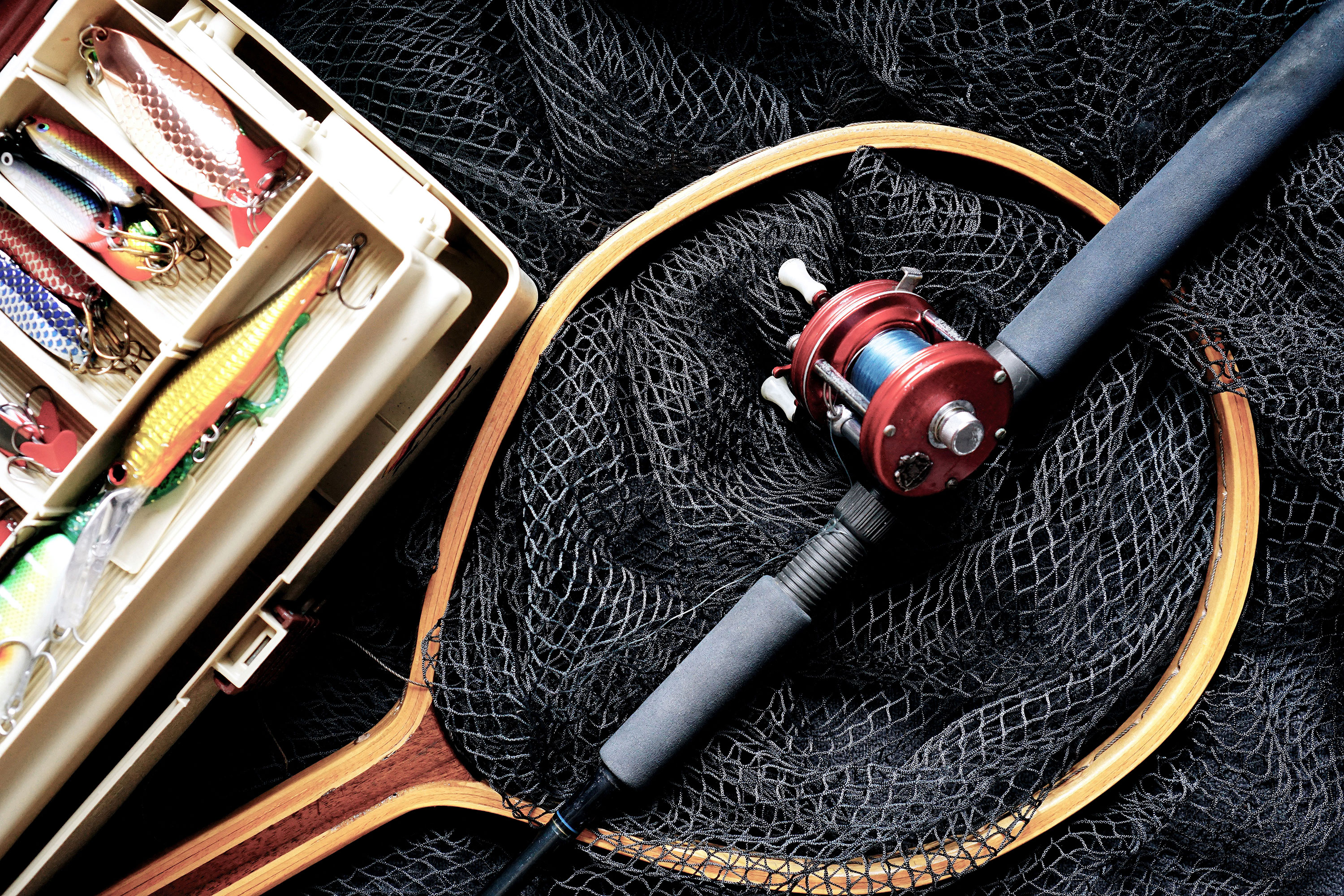 fishing net and rod next to tackle box