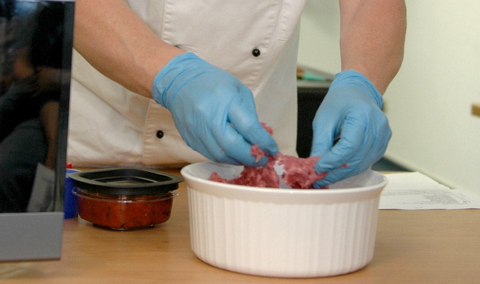 man with rubber gloves inspecting cell-based food product