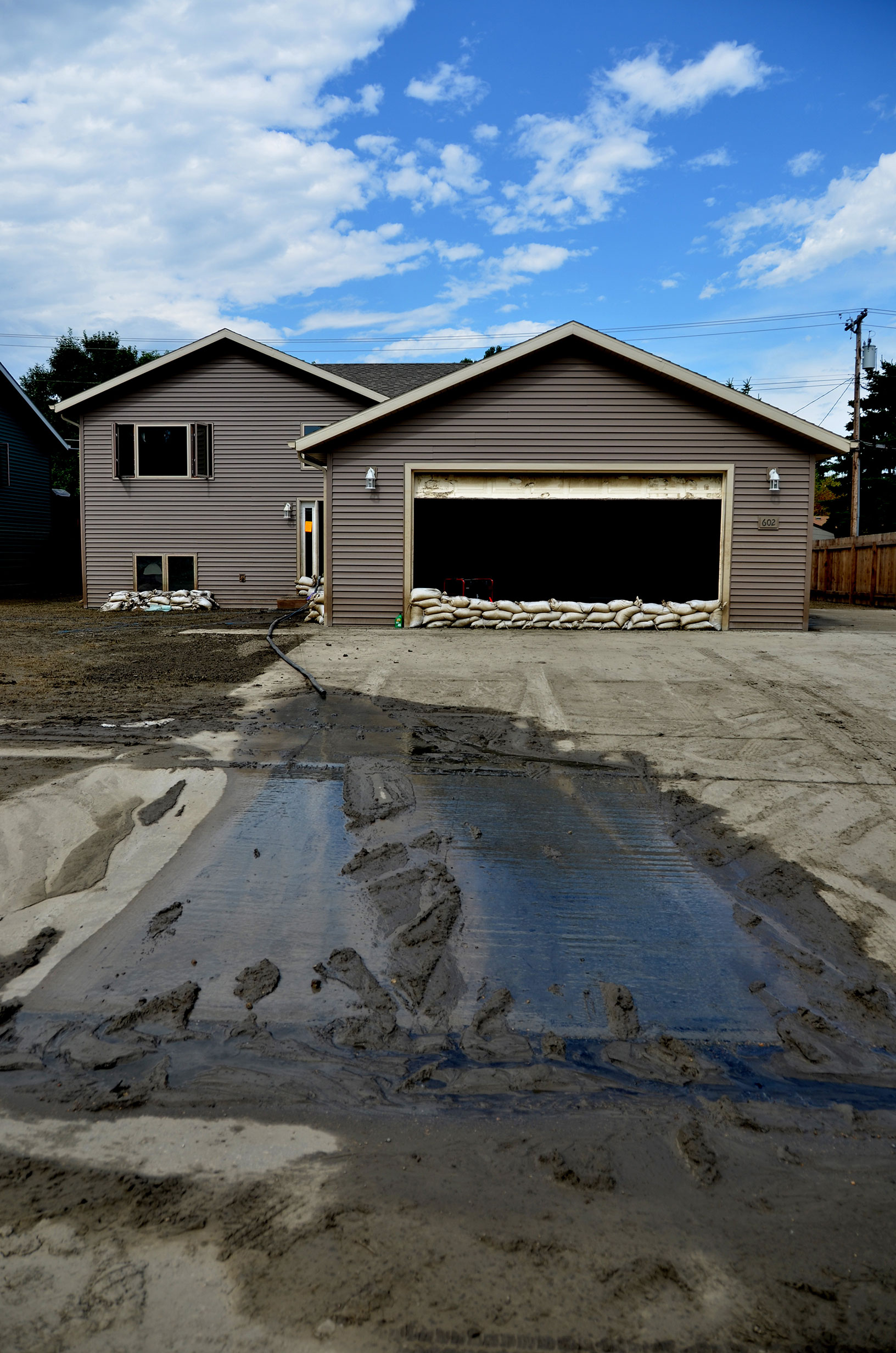 Outside of a home impacted by flooding. Sandbags ar in front of windows and the garage. Photo by David Valdez, FEMA
