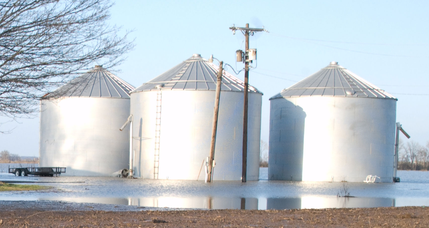 three grain bins in a flooded farm yard. Photo by John Shea, FEMA