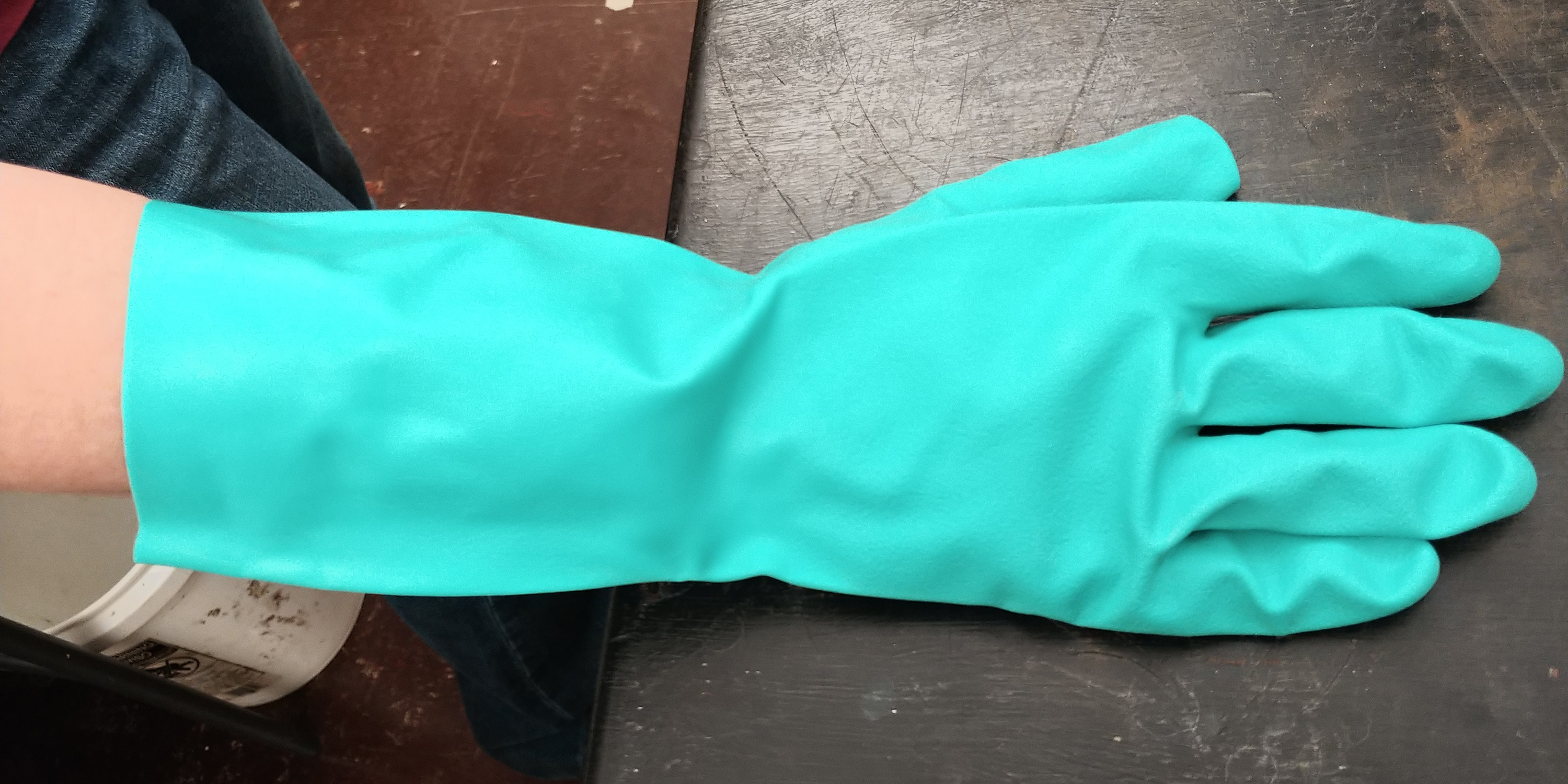 Blue-green glove made out of nitrile material.