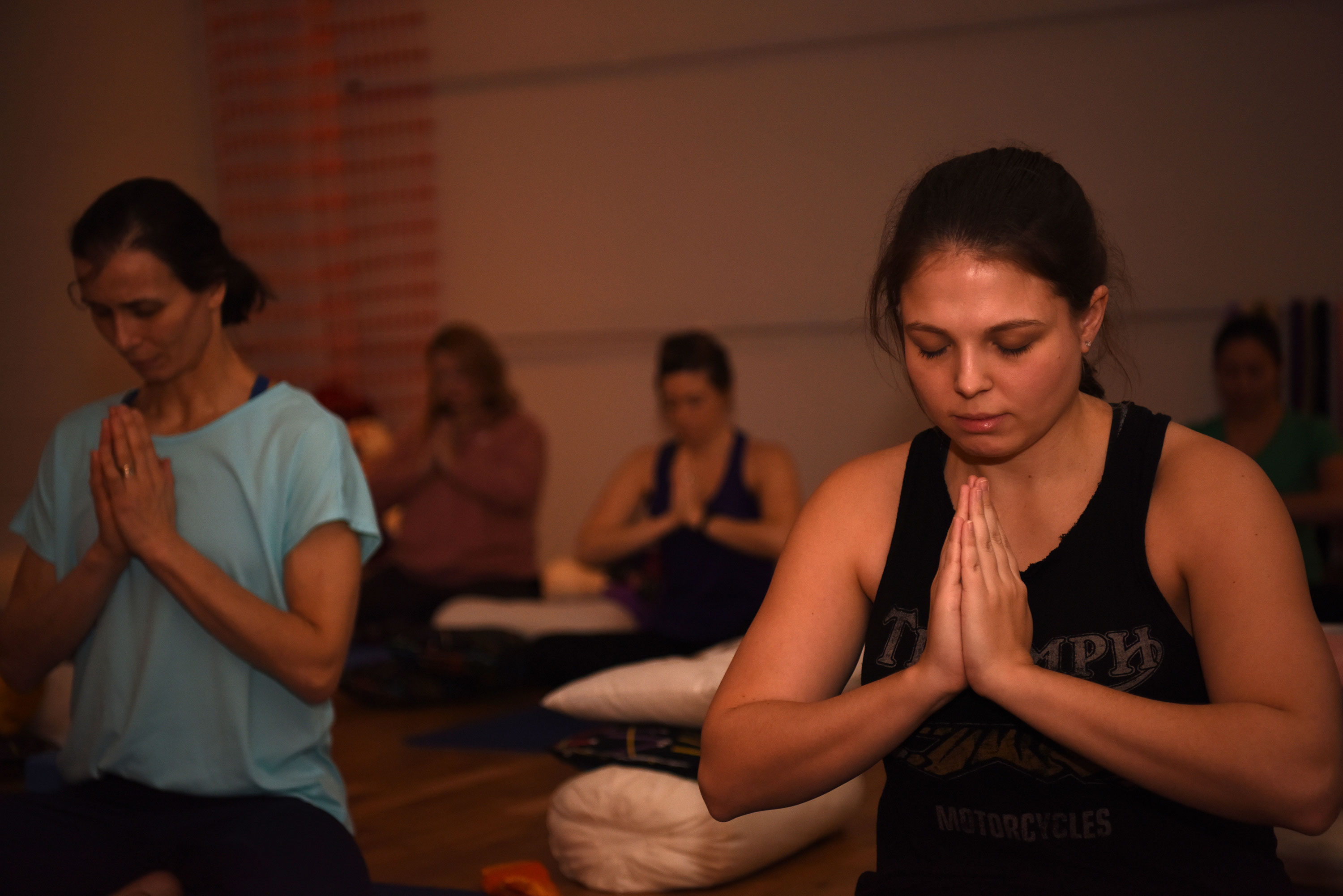 group of young women meditating during a yoga session