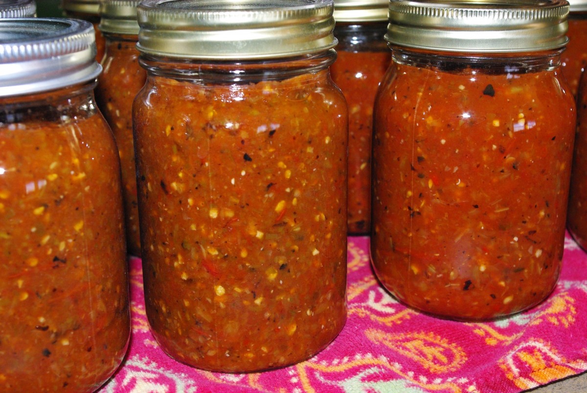Several cans of homemade salsa sitting on a table.