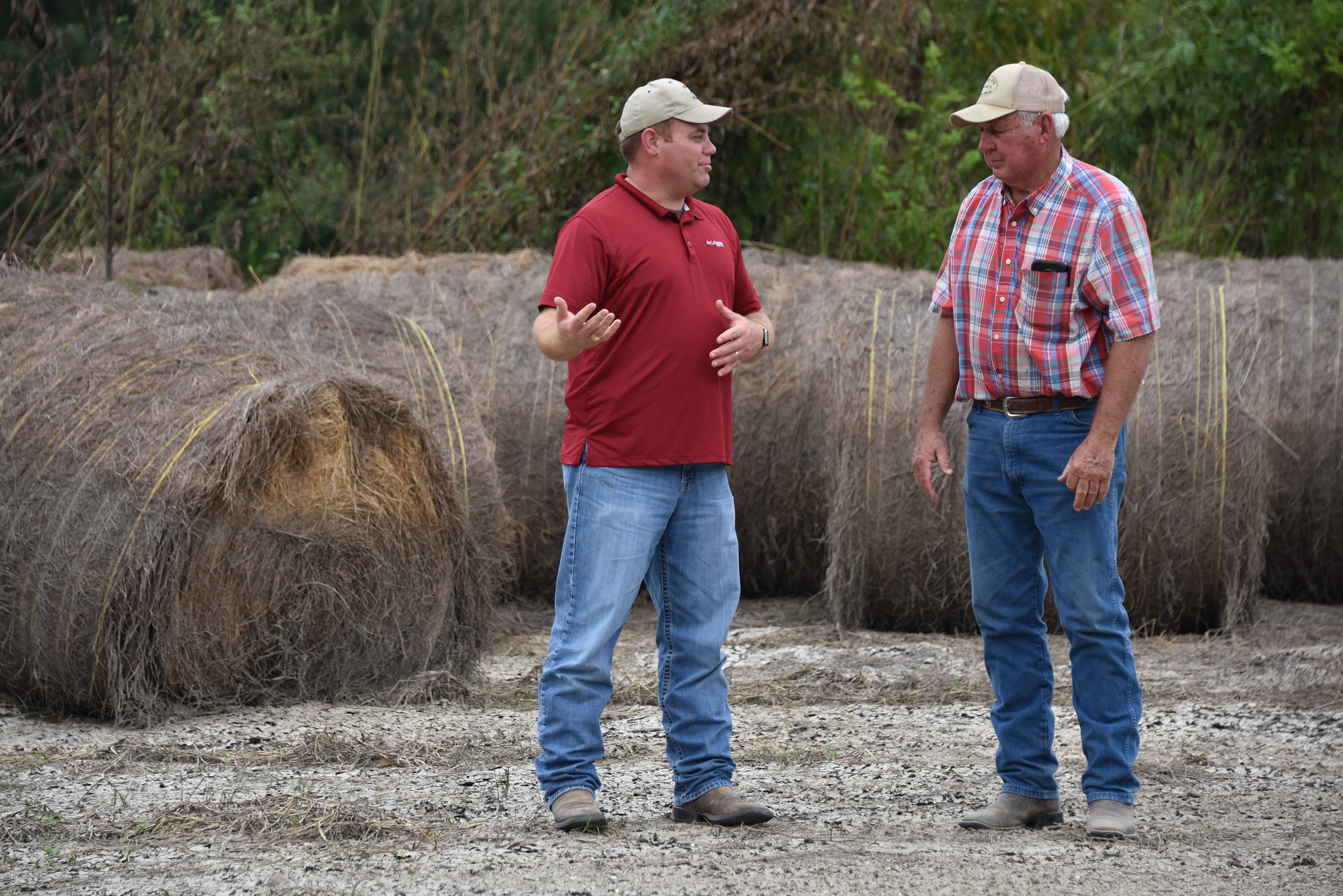 rancher and employee discussing an issue near hay bales