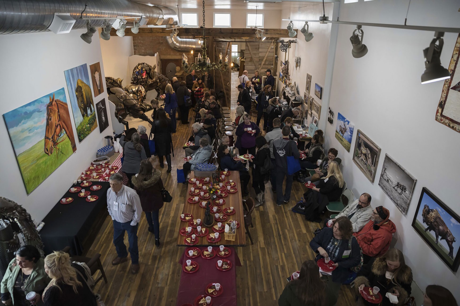 A crowd of Energize Conference attendees enjoying refreshments served in a local art gallery.
