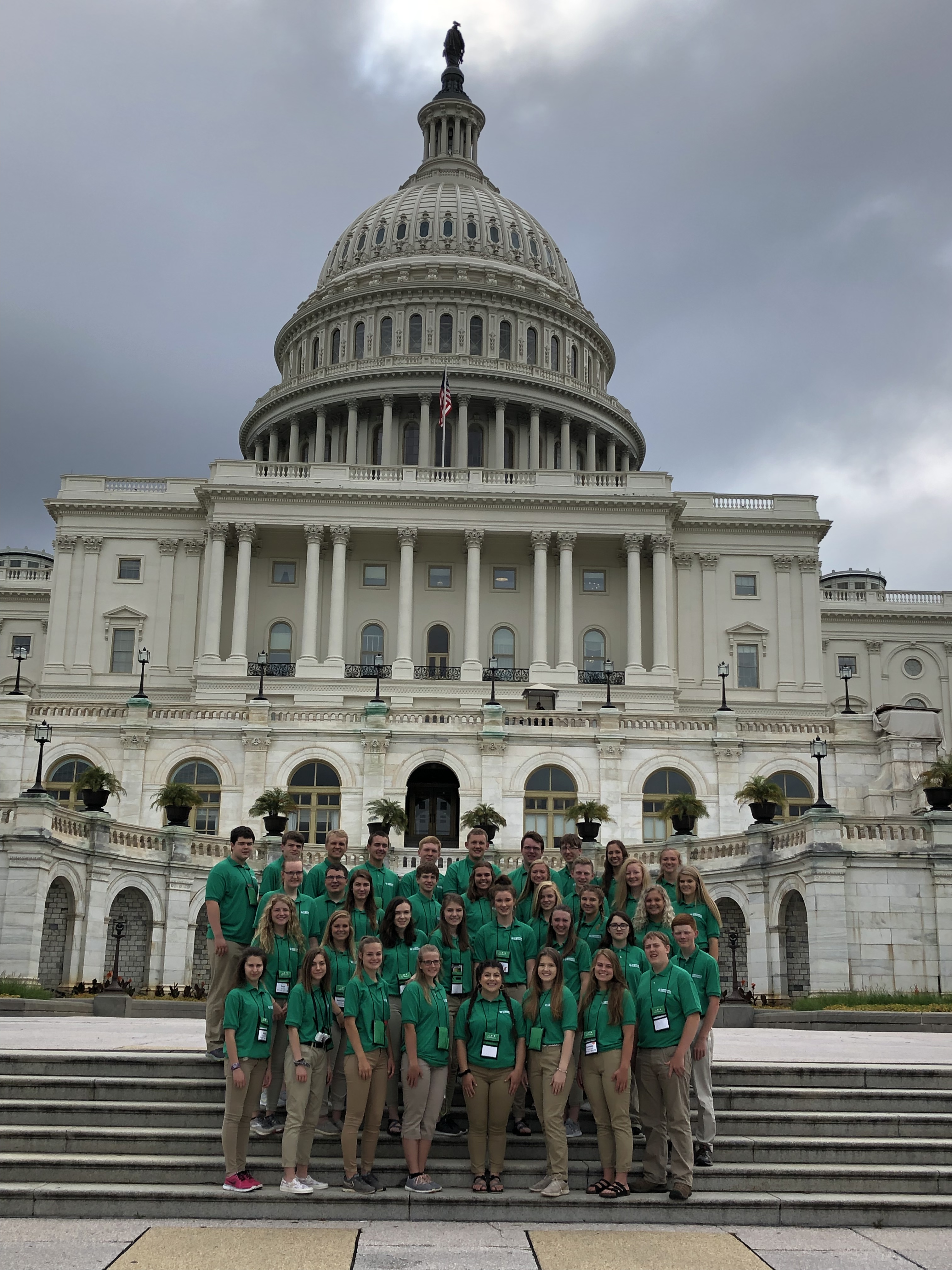 a group of young people standing in front of the US Capitol building