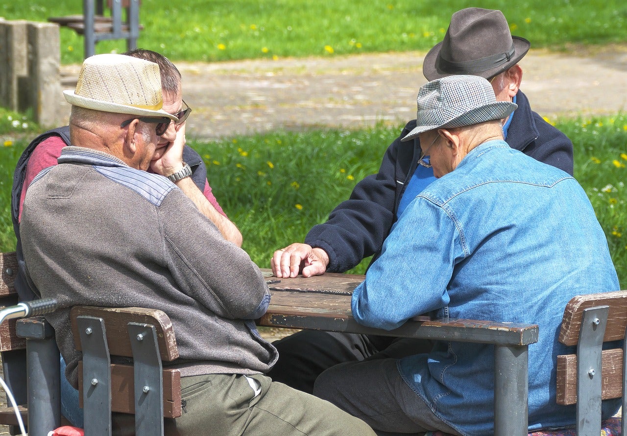 Group of men playing a board game outside.