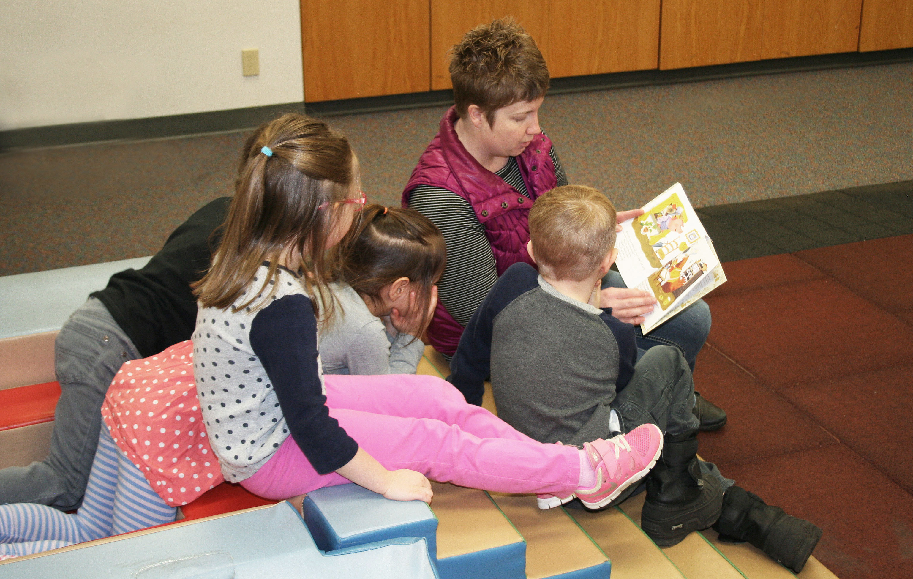 SDSU Extension Early Childhood Field Specialist Audrey Rider reading a book to a group of four children.