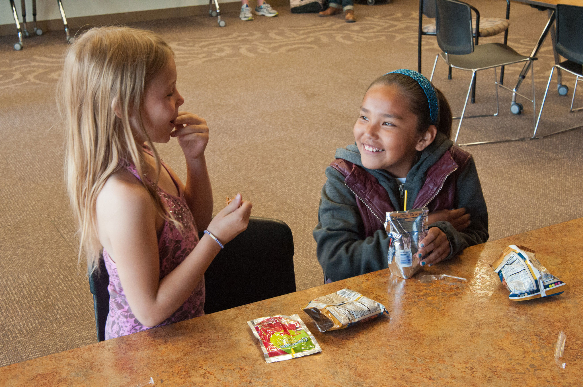 Two young girls enjoying healthy snacks after school. Courtesy: Bob Nichols, USDA [CC BY 2.0].