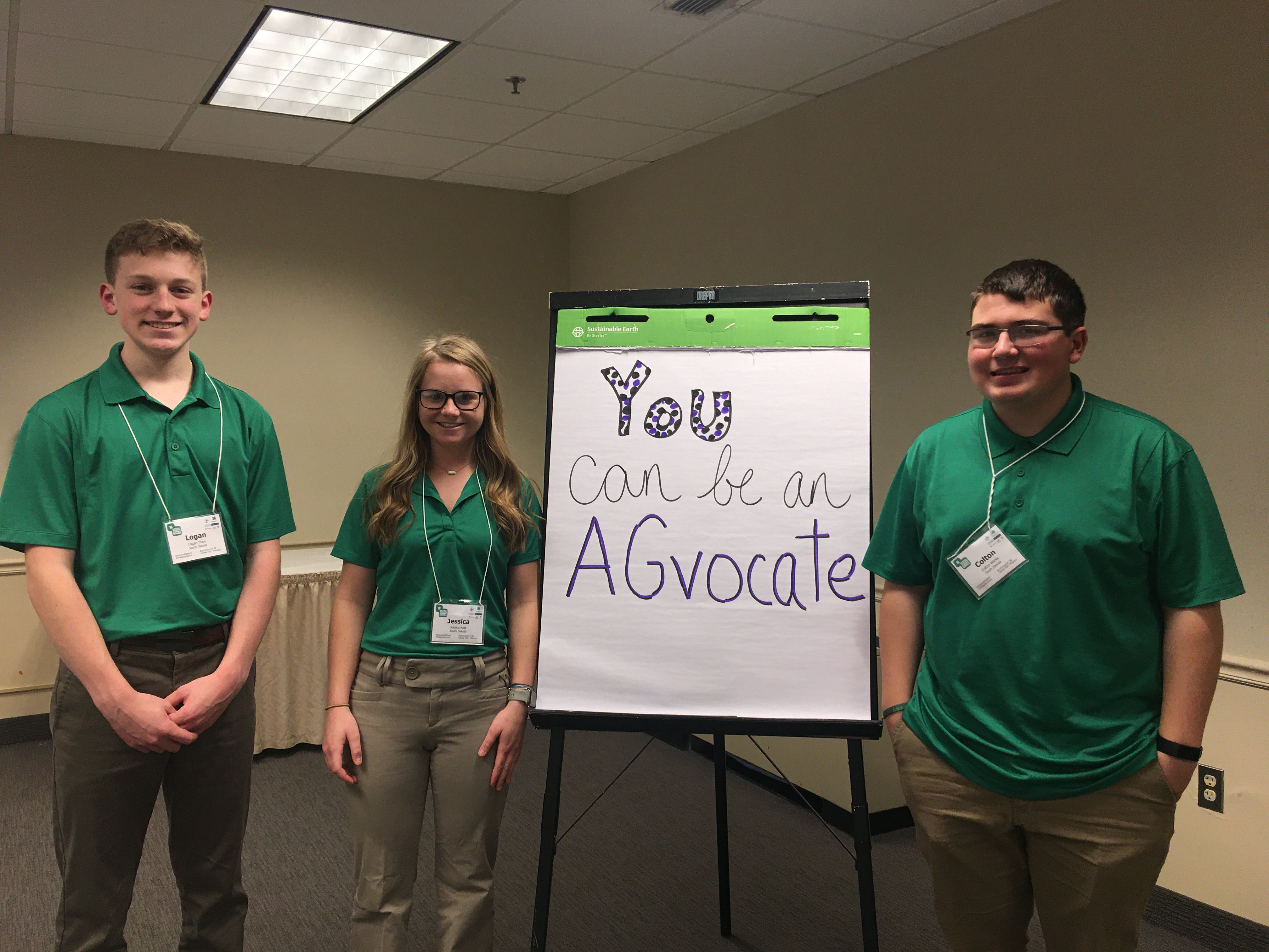 an image of three youth in green shirts with their presentation