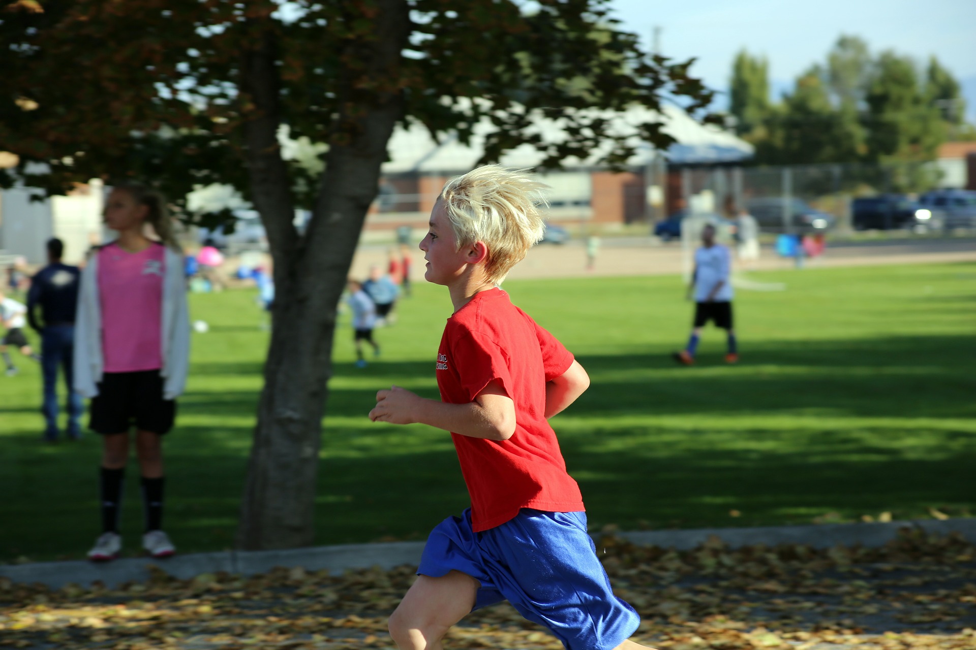 a young boy in a red shirt running