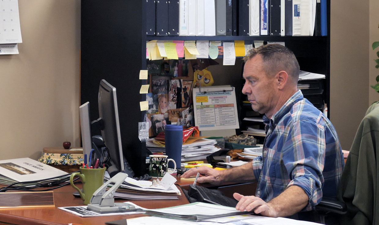 A male producer analyzing records on an office computer.