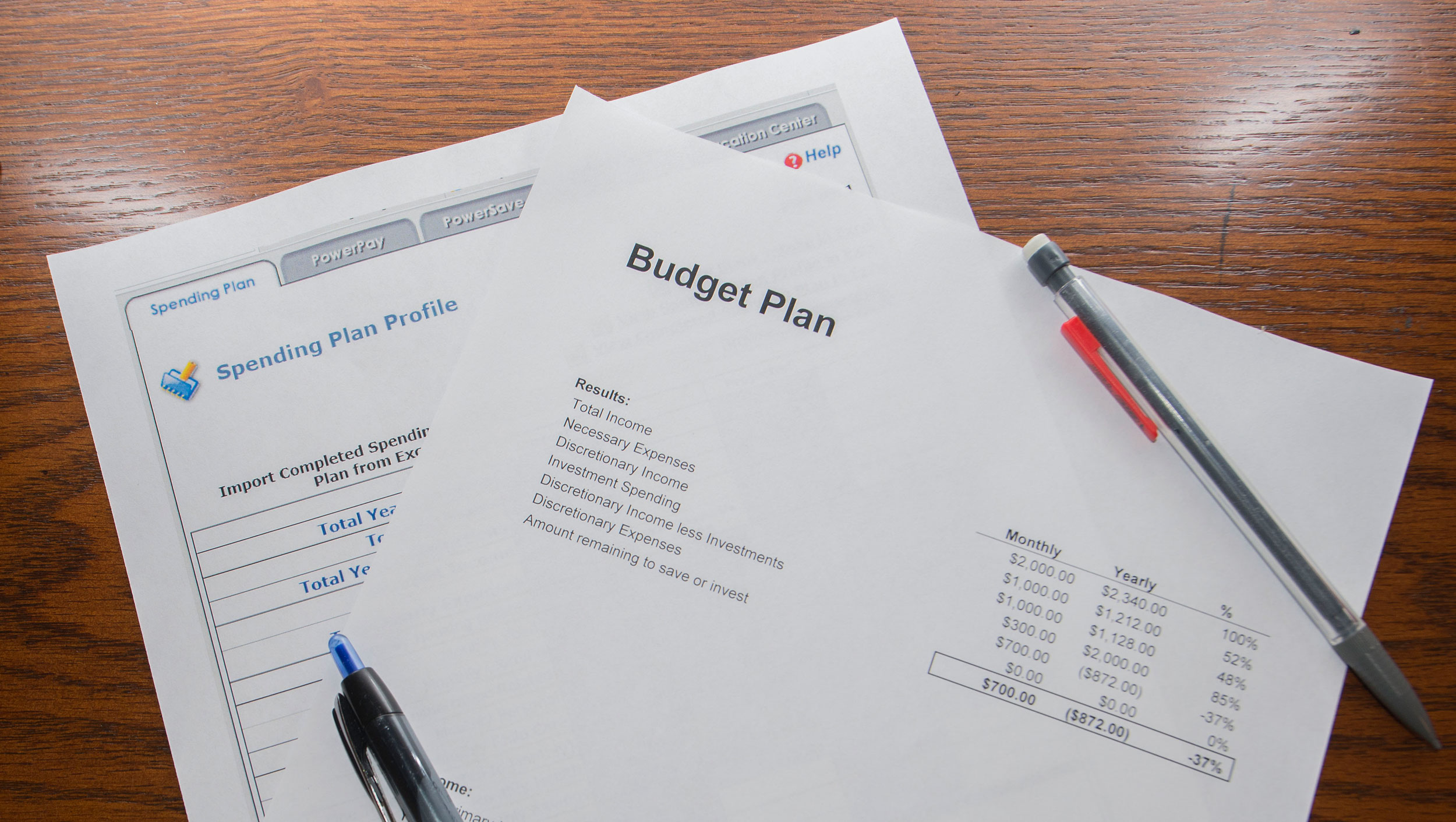 A family budget plan sitting on a desk with a pen and pencil.