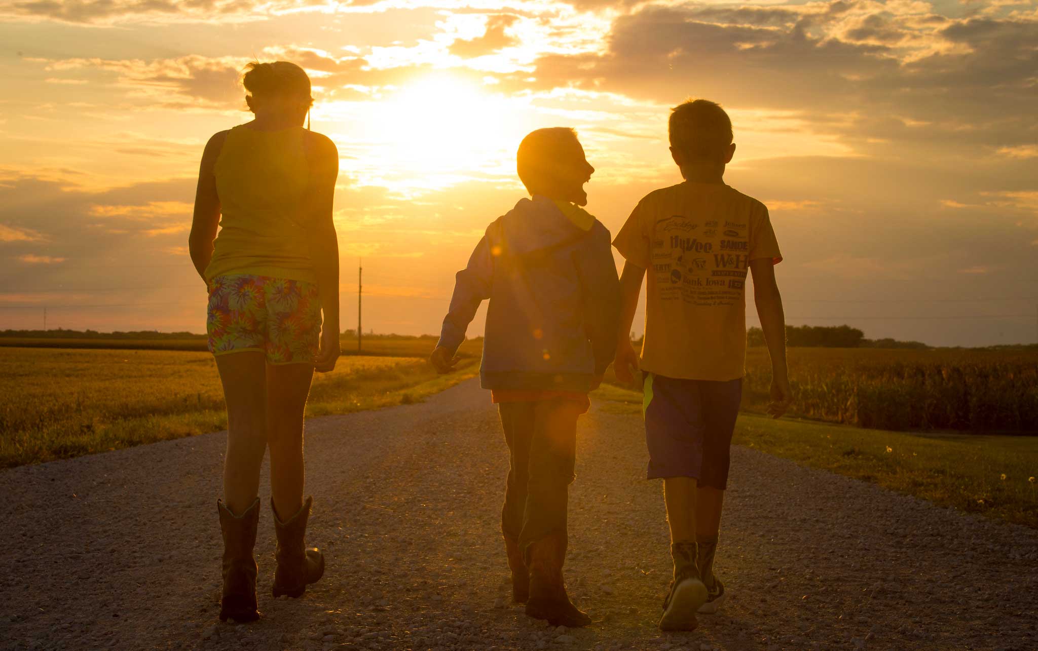 A family going for sunset walk down a country road.