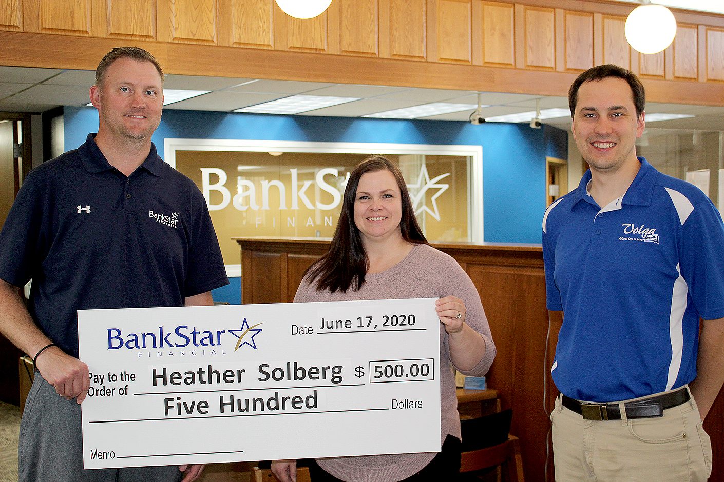 two men and one woman standing with a presentation check