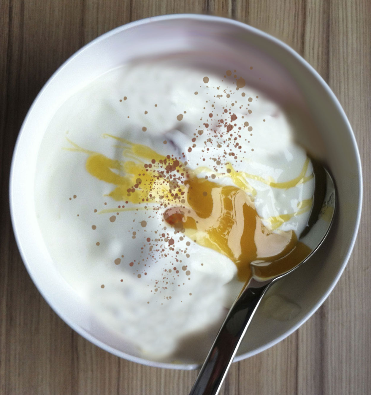 A bowl of plain yogurt mixed with honey and cinnamon.