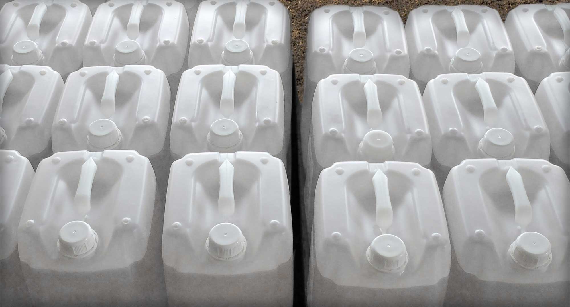 Rows of empty white, plastic pesticide containers.