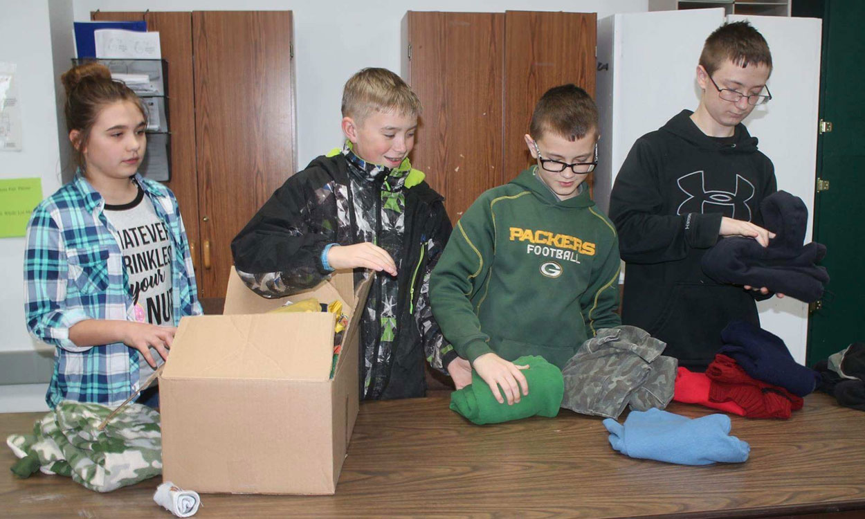 Ryan Sell and several other kids collecting warm clothes for donation.