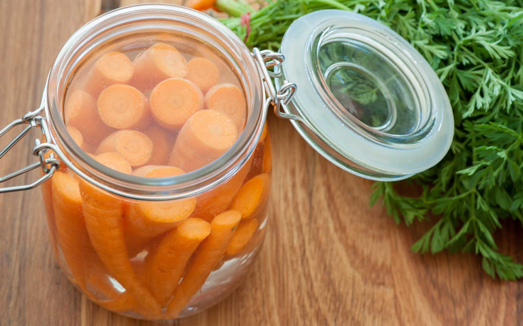 Several cut carrots placed in a canning jar.