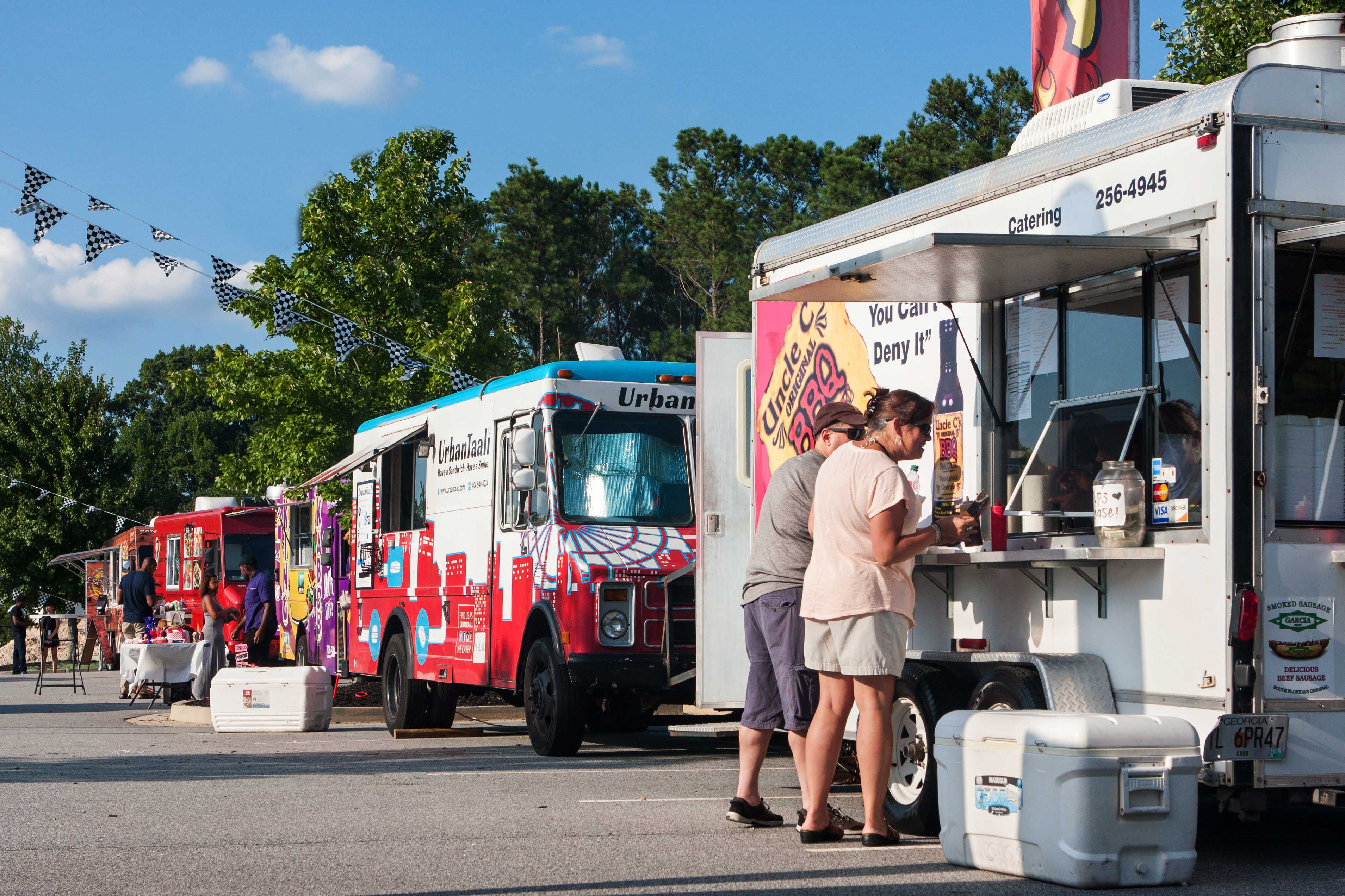 A series of food trucks lined up at a community event.