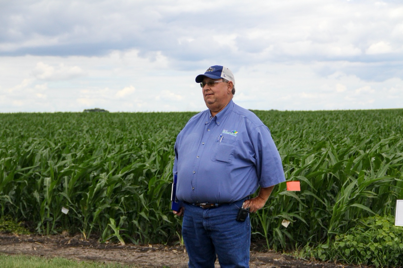 a man standing in front of a cornfield