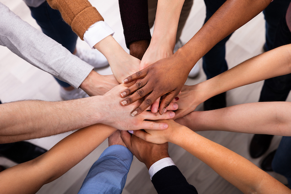 00-03-equity-teaser multiple people's hands stacked together