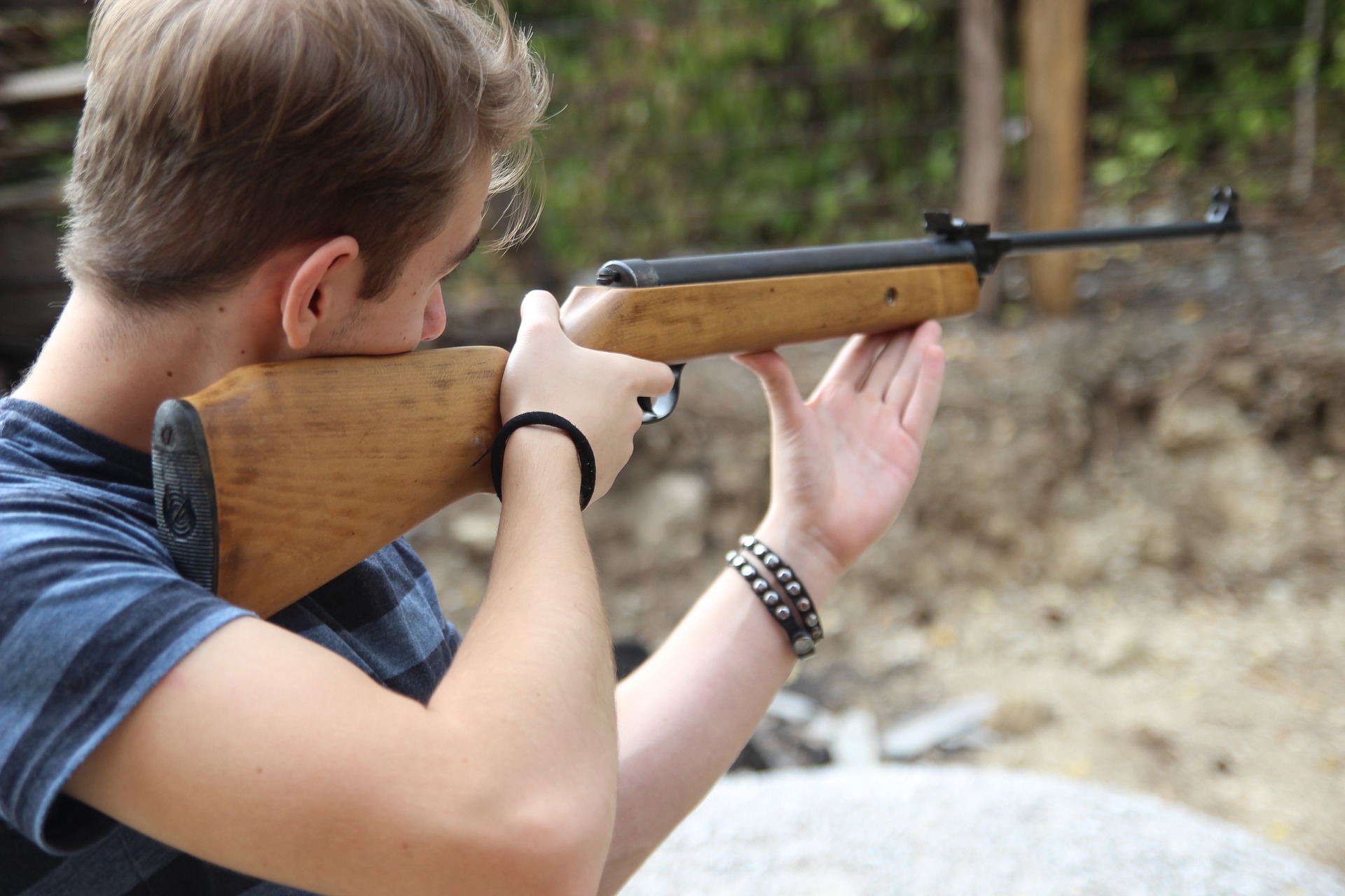 a young man shooting a rifle