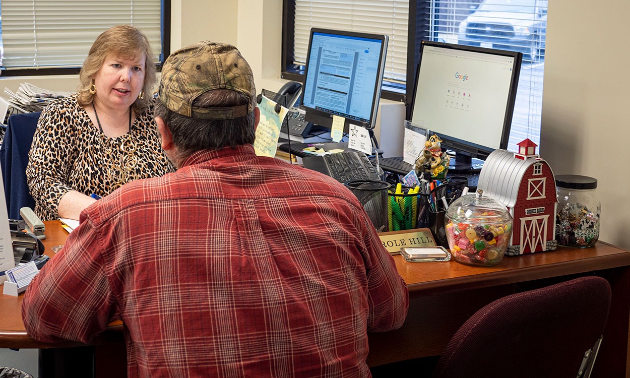 Female FSA employee reviewing paperwork with a male producer.