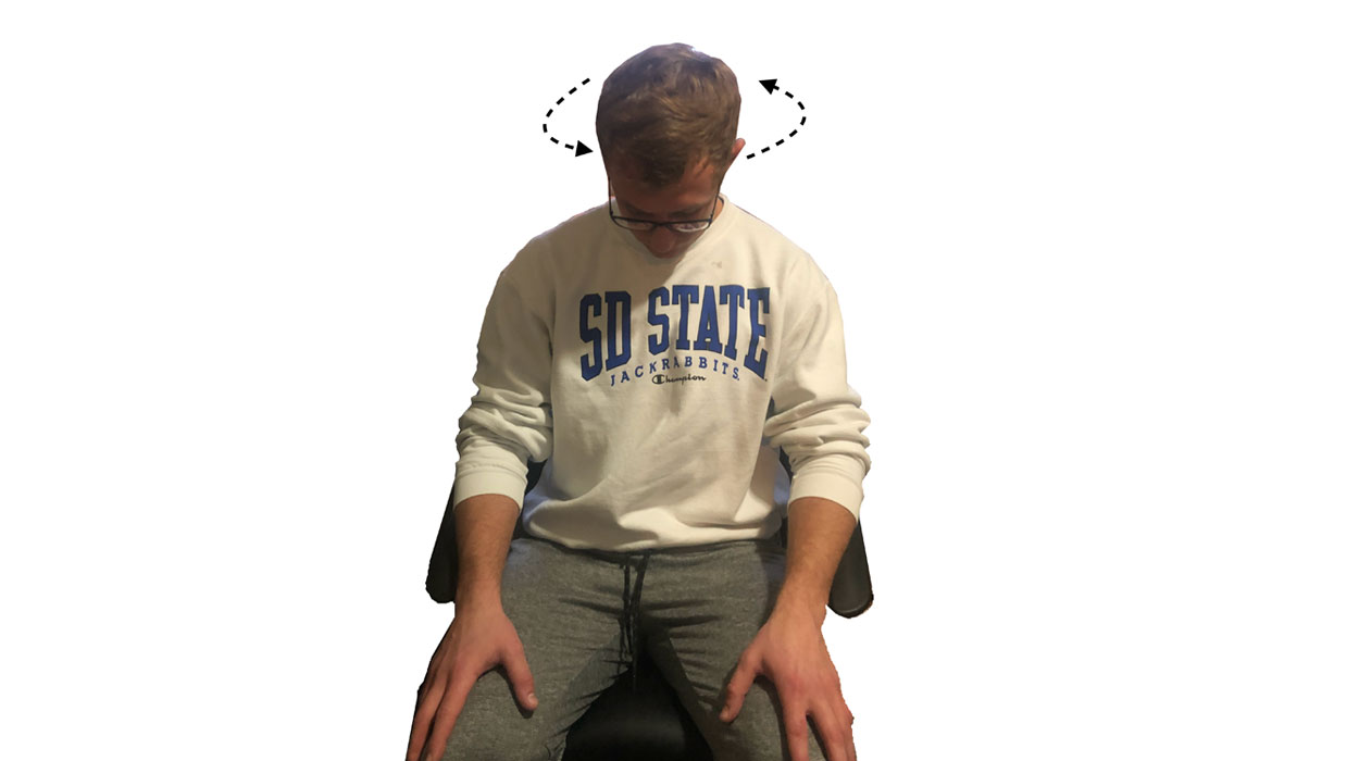 Young man demonstrating the head roll stretch. For a complete description, call SDSU Extension at 605-688-4792.