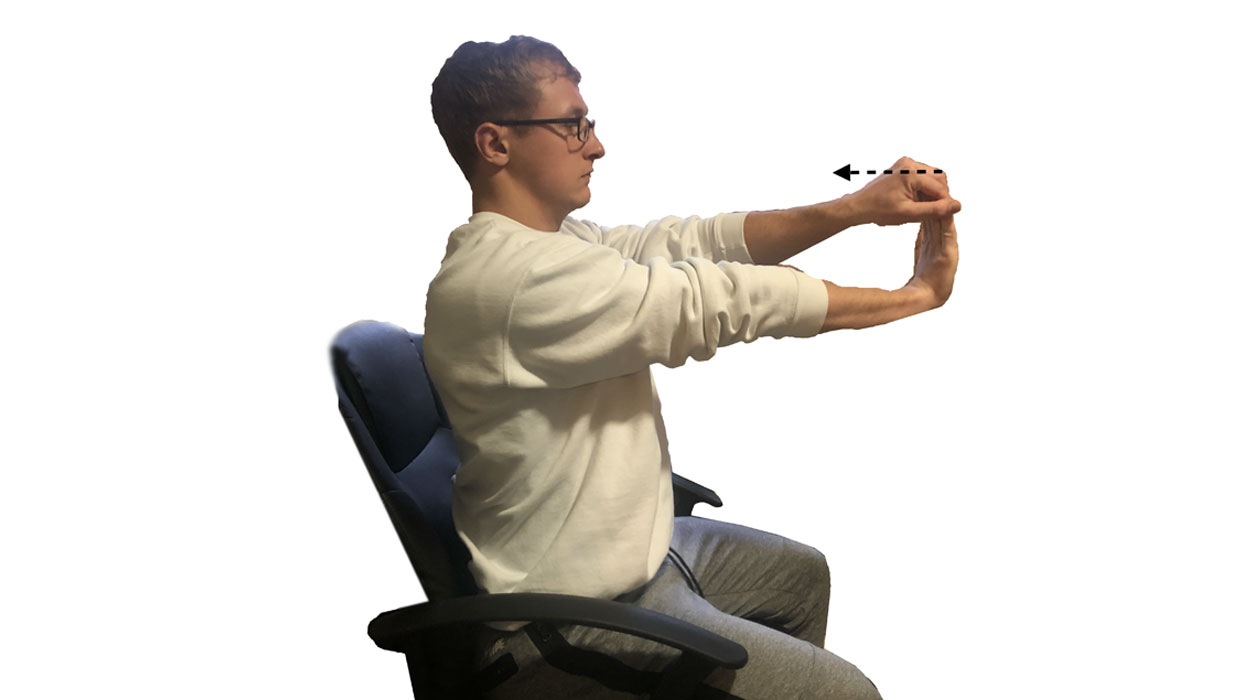 Young man demonstrating the seated wrist stretch. For a complete description, call SDSU Extension at 605-688-4792.