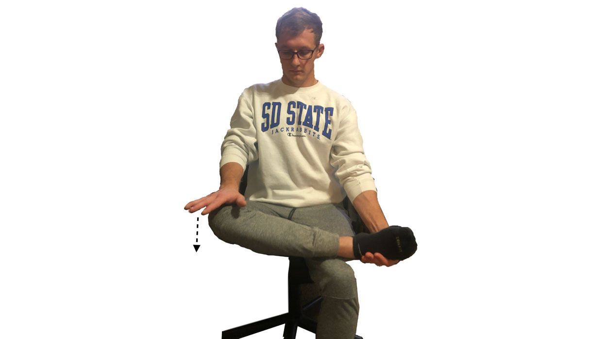 Young man demonstrating the seated hip flexor stretch. For a complete description, call SDSU Extension at 605-688-4792.