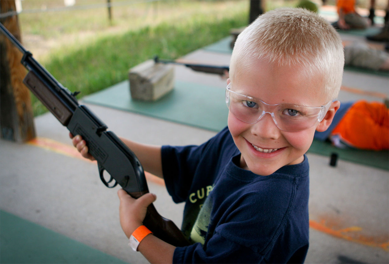 Young boy holding a bb gun.